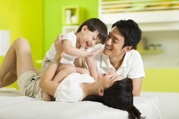 Happy family playing in bedroom