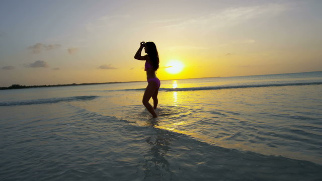 Barefoot ethnic girl carefree dancing on tropical ocean beach 