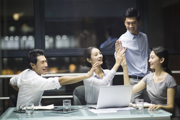 Young business people high fiving in meeting