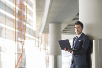 Fototapeta premium Young businessman using laptop in airport