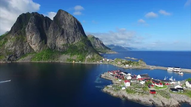Aerial footage of tiny fishing village Hamnoya on Lofoten islands in Norway, popular tourist destination with its typical red houses and natural beauty. Aerial 4k Ultra HD.