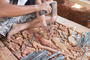 Traditional craftsman carving wood with buddha image