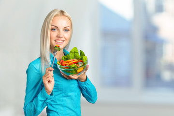 Beautiful girl eating fresh vegetable salad