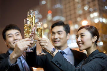 Business people toasting champagne with city lights in the background