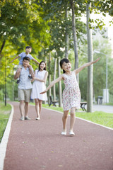 Fototapeta na wymiar Happy young family walking in park