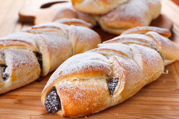 Homemade pastries with poppy seeds on a wooden background