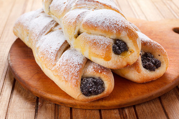 Homemade pastries with poppy seeds on a wooden background