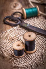 Old sewing kit on the wooden table.