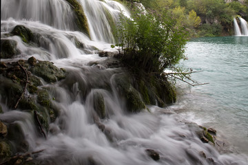Obraz premium Misty waterfalls flowing into lake