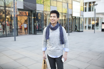 Fashionable young man shopping in city