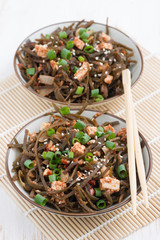 warm sea cabbage salad with fried tofu, top view, vertical