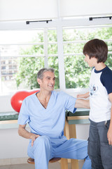 Obraz premium Male therapist with boy in rehab