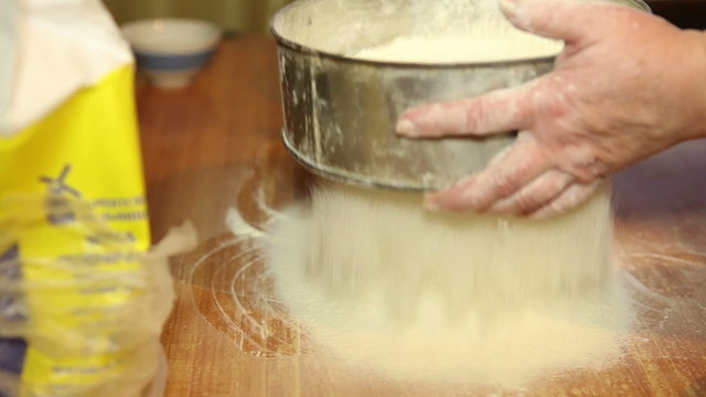woman sifts the flour through a sieve, close-up