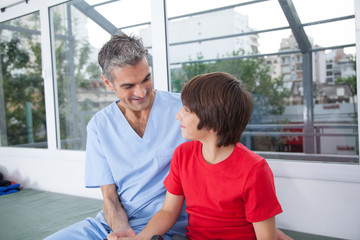 Fototapeta premium Male therapist with boy in rehab