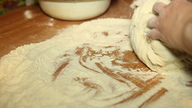 woman knead the dough on the table, close-up