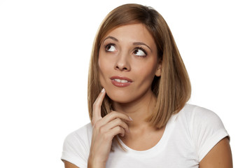 positive pensive young woman on white background