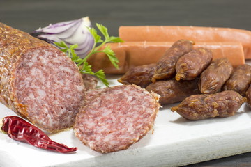 sausages and hotdogs on a white cutting board
