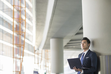 Fototapeta premium Young businessman using laptop in airport