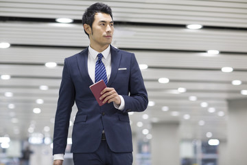 Young businessman holding passport in airport