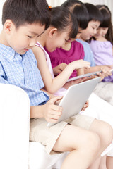 Children playing digital tablet at home