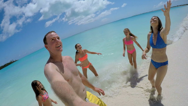 Video selfie of smiling carefree Caucasian family in swimwear 