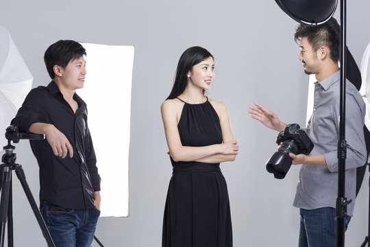 Photographer talking with female model in studio