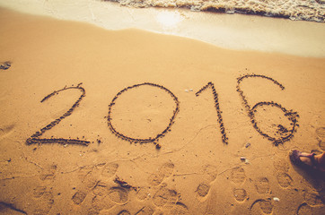 beach background with 2016 new year written on sand