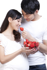 Young couple eating fresh strawberries