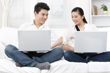 Happy young couple using laptop together