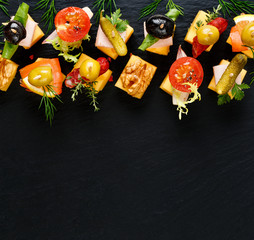 Different types of cheese skewers on a black background. Delicious snack