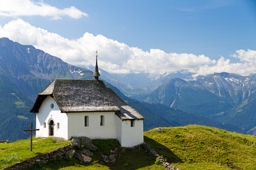 Fototapeta na wymiar Little church in the mountains of the Swiss alps on a beautiful day