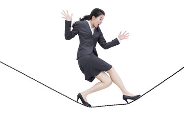 Businesswoman walking on rope