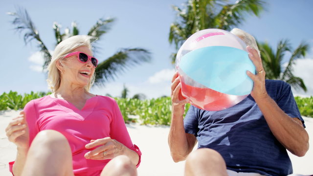 Retired Caucasian couple having fun outdoor with a beach ball