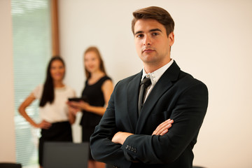Young Business man   standing in first plain with coworkers in b