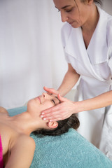 Fototapeta na wymiar beauty, spa, resort and relaxation concept - beautiful woman in spa salon getting massage
