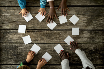 Four children of mixed races assembling a heart shape of white c