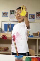 Boy Holding Up Yellow Painted Hand