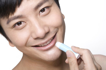 Young man using lip balm