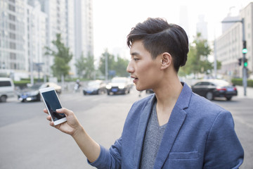 Young man waiting for taxi with smart phone