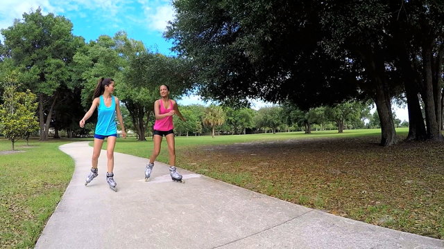 Young happy multi ethnic American girls enjoying roller skating outdoor