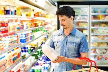 man buys milk at the supermarket