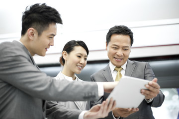 Fototapeta premium Cheerful business persons with digital tablet on subway platform