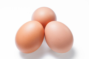 Three brown chicken egg on white background