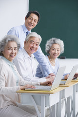 Fototapeta premium Senior adults having computer class at school