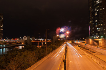 Chicago buildings and street at night during fireworks display near lake