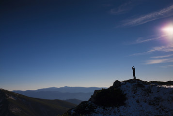 The silhouette of a man in the mountains.