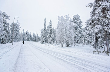 Man in the snow covered road in Ruka in Finland in the Arctic circle