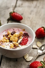 Breakfast smoothie bowl with strawberries granola nuts and Chia seeds
