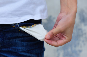 woman showing she has no money by turning out her pocket