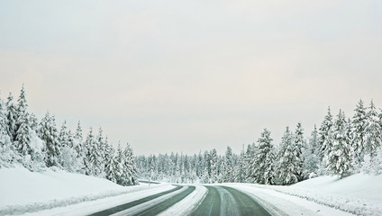 Snow covered road to Finland on the Arctic pole circle